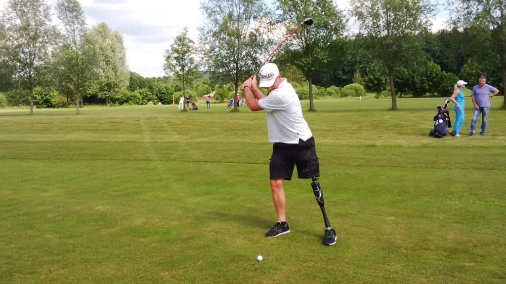 Amputee Mathias wearing a Linx prosthetic leg and playing golf