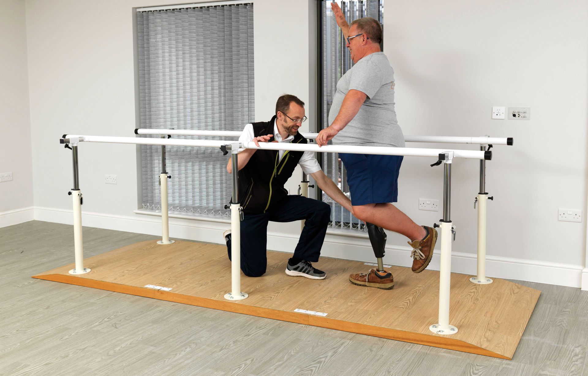 Prosthetist With Patient On Bars (1)