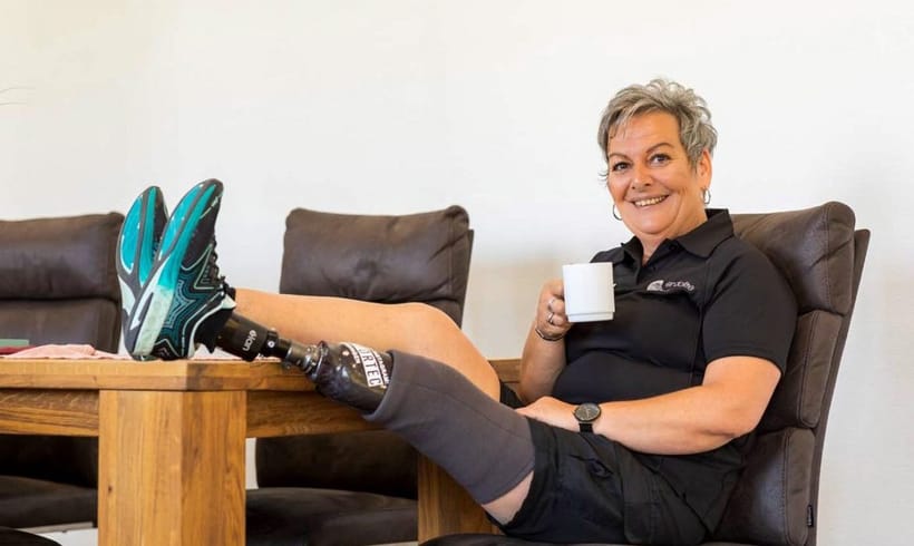 Sabine Kilz drinking tea with prosthetic Elan foot on table